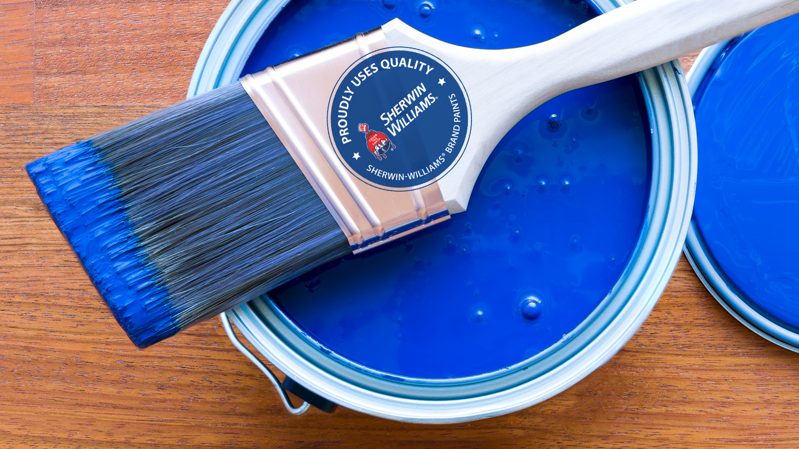Why we use Sherwin-Williams Brand Paints Feature Image: A paint brush rested on top of a blue paint can